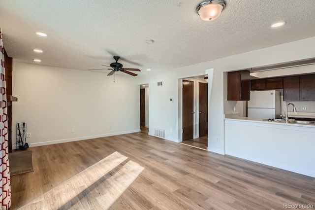 unfurnished living room with light wood-style floors, a ceiling fan, a sink, and recessed lighting