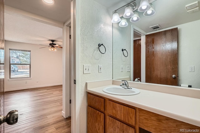 bathroom featuring a ceiling fan, visible vents, wood finished floors, and vanity