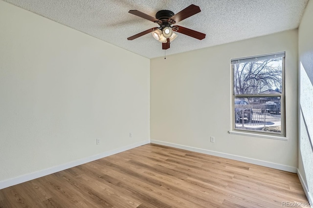 unfurnished room with baseboards, light wood-style flooring, and a textured ceiling