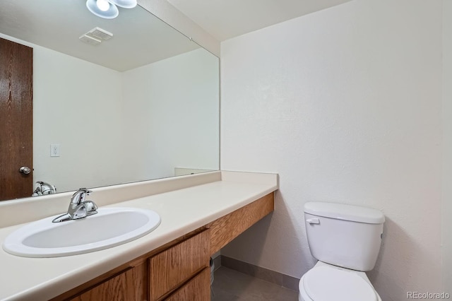 bathroom featuring toilet, baseboards, visible vents, and vanity