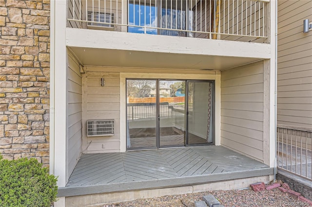 view of exterior entry featuring heating unit and stone siding