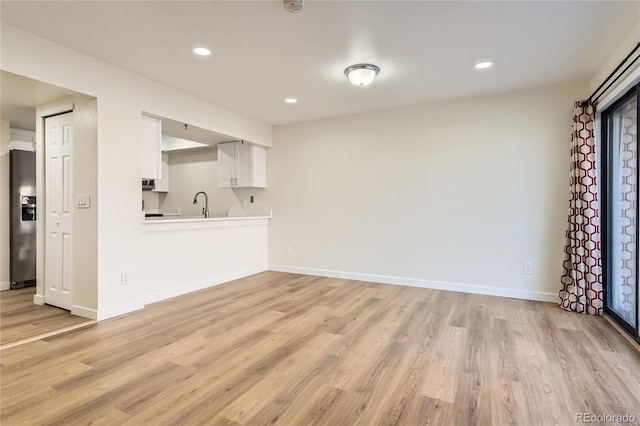 unfurnished living room with light wood-style flooring, baseboards, and recessed lighting