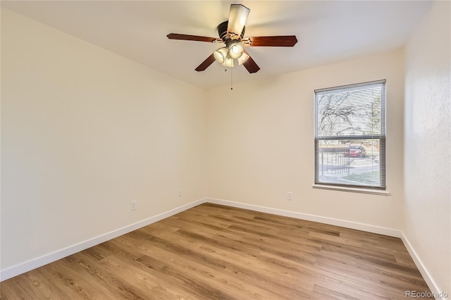 unfurnished room with baseboards, a ceiling fan, and light wood-style flooring