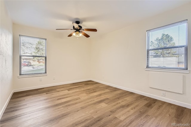 spare room featuring ceiling fan, baseboards, and wood finished floors