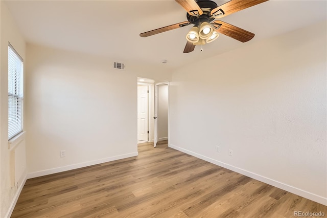 unfurnished room featuring baseboards, visible vents, and light wood-style floors