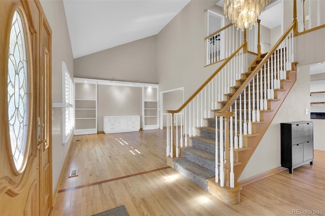 5622 E Weaver Cir, Centennial, CO 80111 - foyer featuring high vaulted ceiling, wood finished floors, stairs, baseboards, and a chandelier
