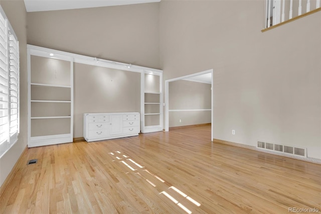 5622 E Weaver Cir, Centennial, CO 80111 - unfurnished living room with a towering ceiling, wood finished floors, and baseboards