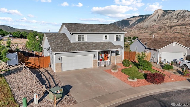 80 Cliff View Cir, Parachute, CO 81635 - traditional home featuring a mountain view, concrete driveway, a shingled roof, brick siding, and a porch