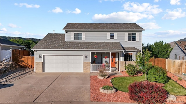 80 Cliff View Cir, Parachute, CO 81635 - traditional home with covered porch, brick siding, driveway, an attached garage, and a shingled roof