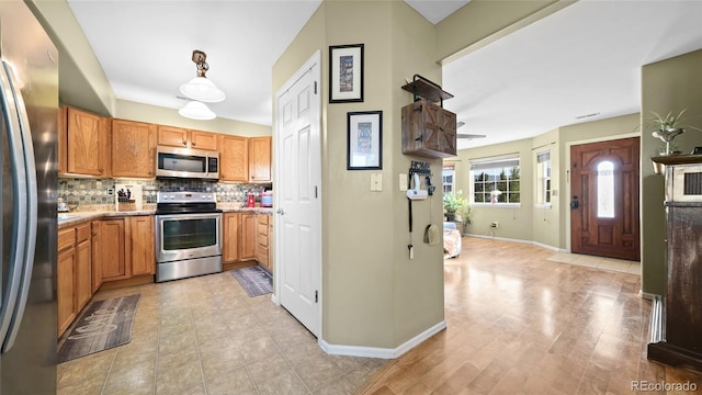 80 Cliff View Cir, Parachute, CO 81635 - kitchen with appliances with stainless steel finishes, decorative backsplash, light tile patterned flooring, and brown cabinets