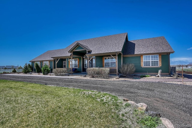 55610 E 40th Ave, Strasburg, CO 80136 - view of front facade featuring a front yard, roof with shingles, and a porch