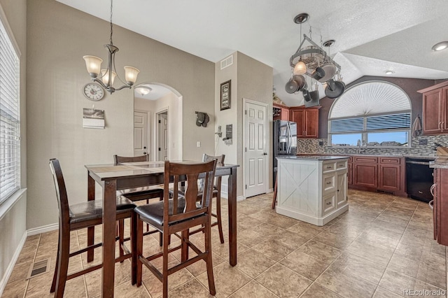 55610 E 40th Ave, Strasburg, CO 80136 - dining space with lofted ceiling, a chandelier, and arched walkways