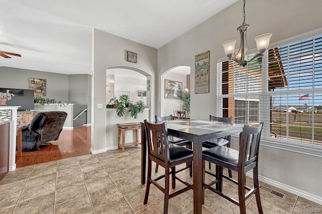 55610 E 40th Ave, Strasburg, CO 80136 - tiled dining space featuring arched walkways, a chandelier, and a ceiling fan