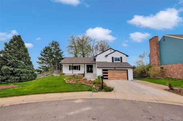 split level home featuring a garage, fence, a front yard, a shingled roof, and concrete driveway