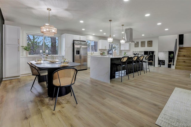 dining room with stairs, recessed lighting, a notable chandelier, and light wood-style flooring