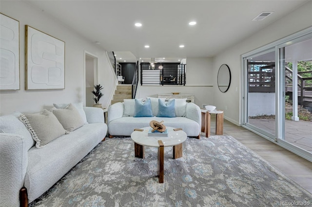 living area with visible vents, stairs, wood finished floors, baseboards, and recessed lighting