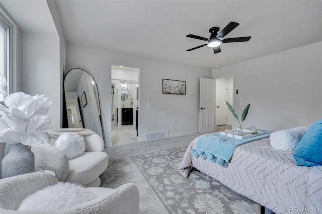 bedroom featuring ceiling fan, visible vents, baseboards, connected bathroom, and light carpet