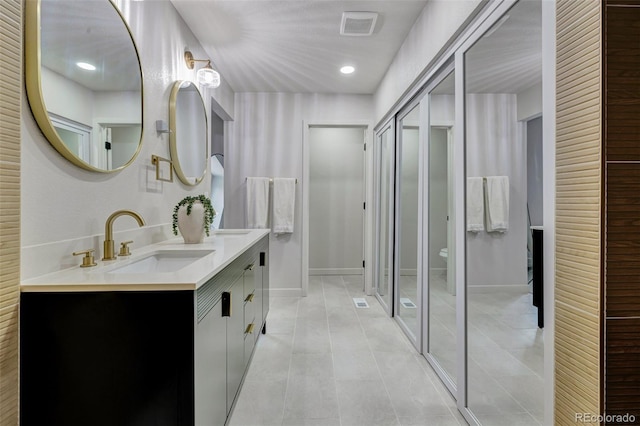 full bath with double vanity, visible vents, a shower stall, a sink, and tile patterned floors