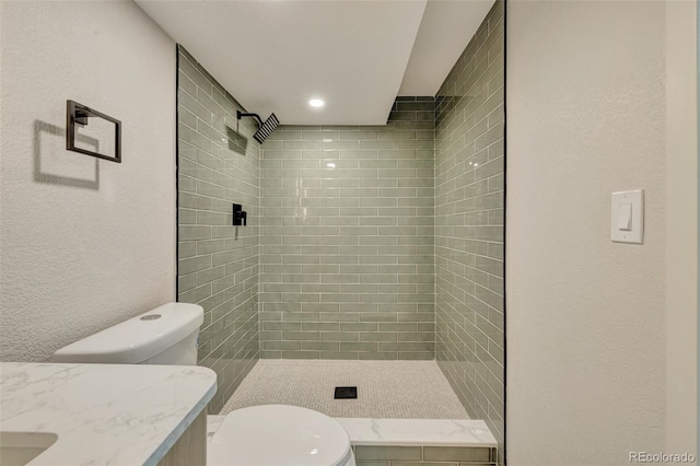 bathroom with vanity, a shower stall, and toilet
