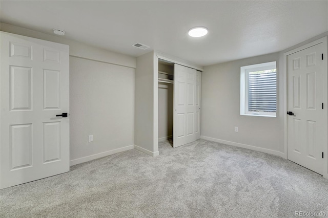 unfurnished bedroom featuring baseboards, carpet, visible vents, and a closet