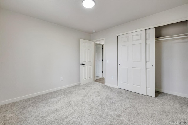 unfurnished bedroom with carpet floors, baseboards, and a closet
