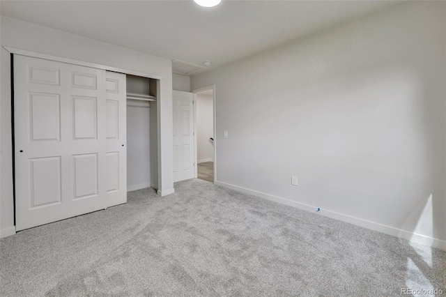 unfurnished bedroom featuring baseboards, carpet, and a closet