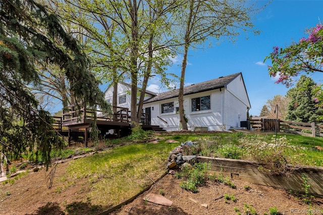 rear view of property with fence and a deck