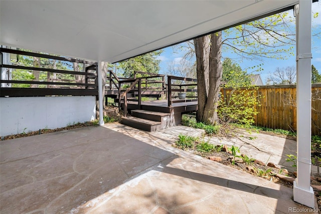 view of patio featuring fence and a wooden deck