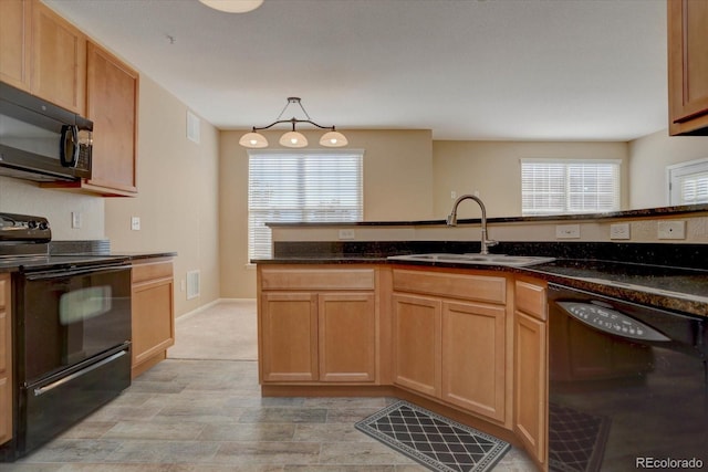 kitchen with hanging light fixtures, visible vents, a sink, black appliances, and dark stone counters