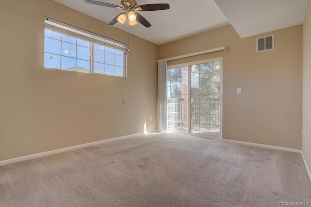 carpeted empty room featuring ceiling fan, plenty of natural light, baseboards, and visible vents