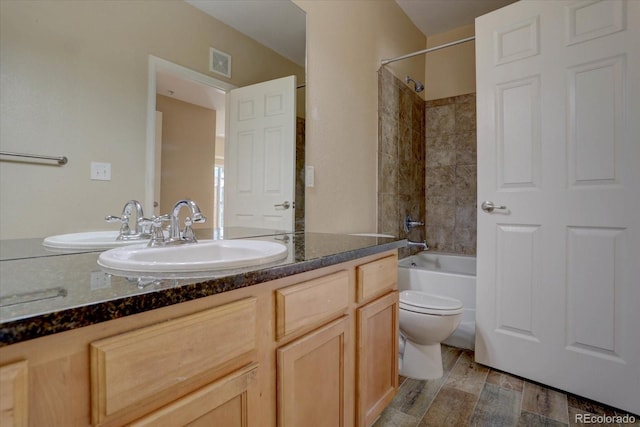 full bath with toilet, visible vents, vanity, wood finished floors, and bathing tub / shower combination