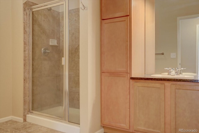 bathroom with tile patterned flooring, vanity, and a shower with door