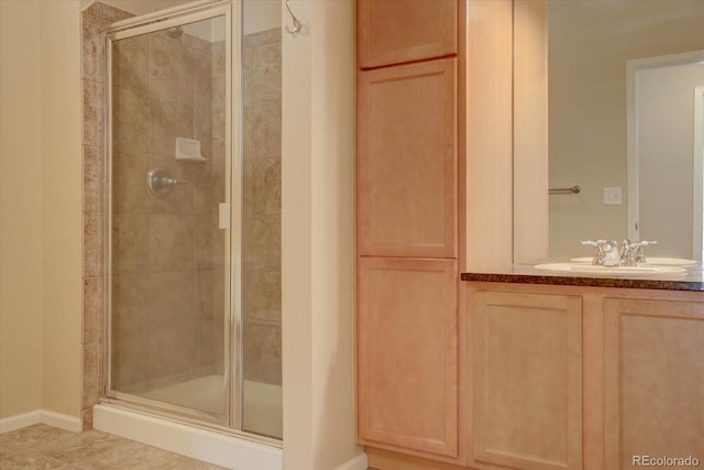 full bath with vanity, baseboards, a stall shower, and tile patterned flooring