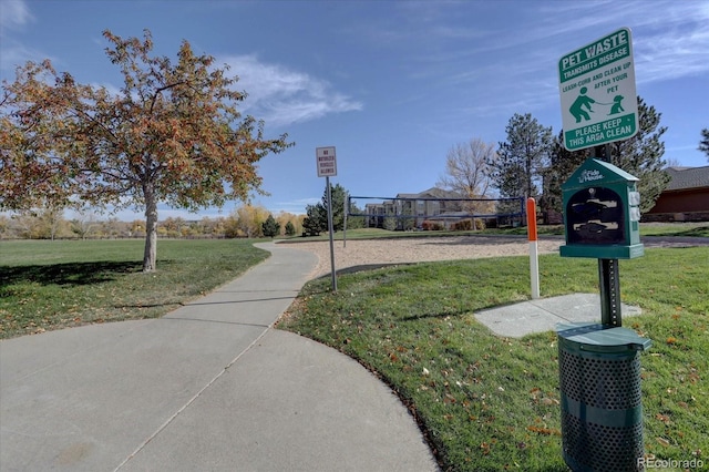 view of home's community featuring volleyball court and a lawn