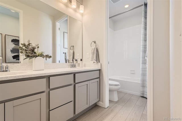 full bathroom with vanity, toilet, wood-type flooring, and shower / tub combo