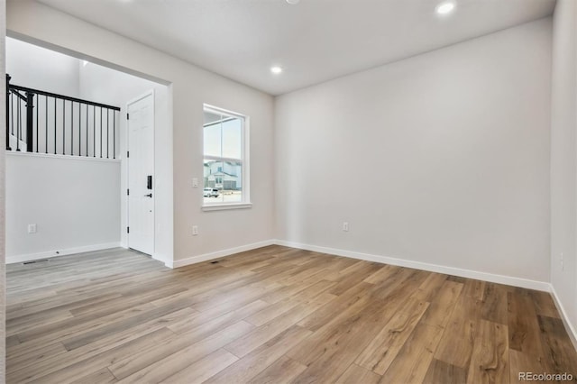 unfurnished room featuring recessed lighting, light wood-style flooring, and baseboards