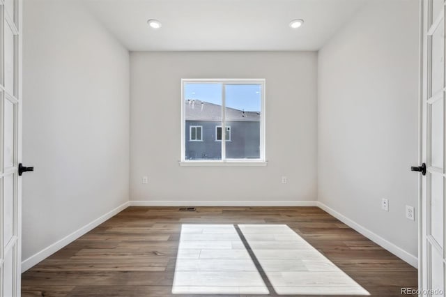 spare room with recessed lighting, wood finished floors, and baseboards