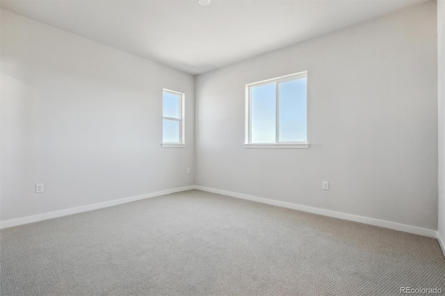 unfurnished room featuring baseboards and light colored carpet