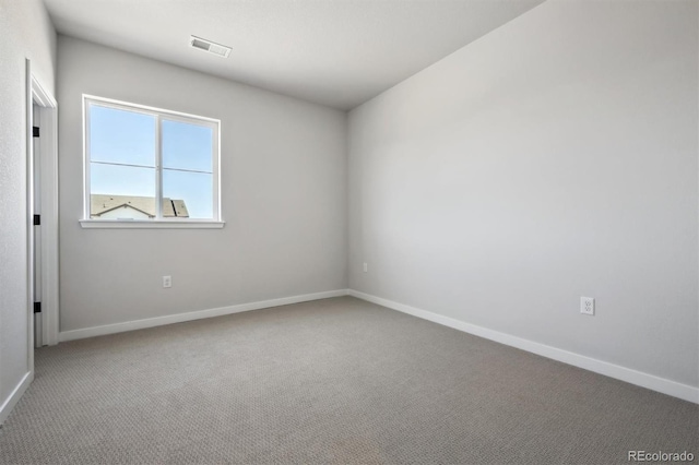 carpeted empty room featuring baseboards and visible vents