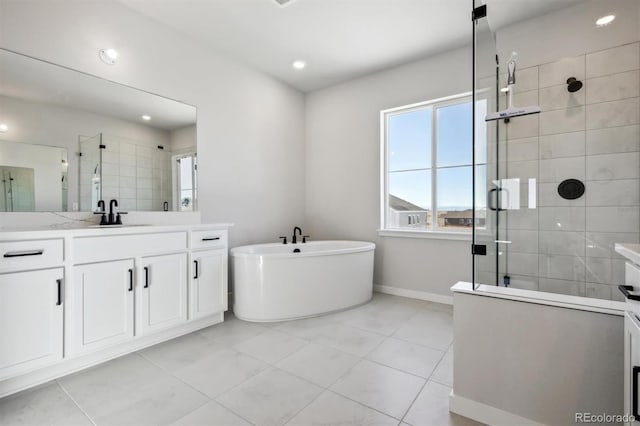 full bathroom featuring a freestanding bath, a stall shower, vanity, and baseboards