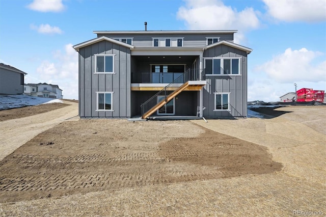 back of property featuring board and batten siding and stairway