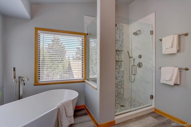 32091 Black Widow Dr, Conifer, CO 80433 - bathroom with wood finished floors, plenty of natural light, and a freestanding bath