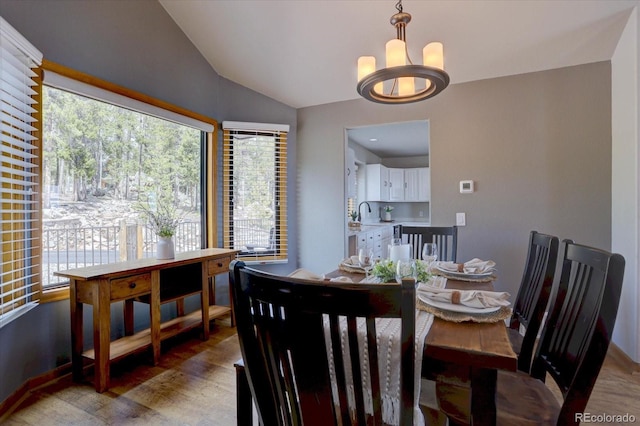 32091 Black Widow Dr, Conifer, CO 80433 - dining area featuring a chandelier, lofted ceiling, plenty of natural light, and light wood-type flooring