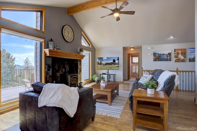 32091 Black Widow Dr, Conifer, CO 80433 - living area with a wood stove, a ceiling fan, beamed ceiling, high vaulted ceiling, and light wood-style floors