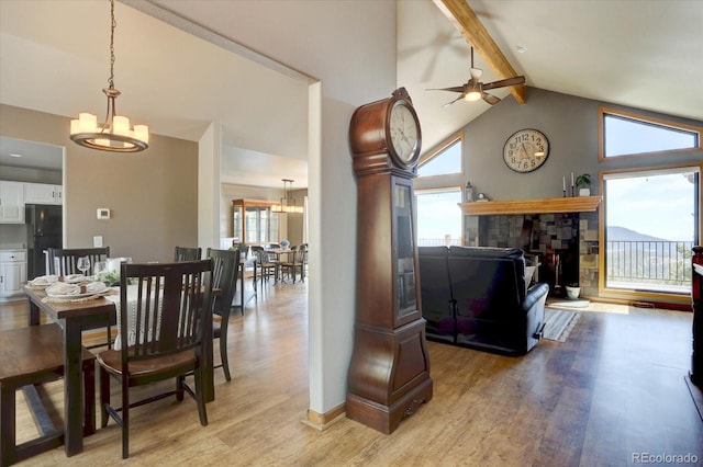 32091 Black Widow Dr, Conifer, CO 80433 - dining space with a chandelier, a ceiling fan, light wood finished floors, beam ceiling, and plenty of natural light