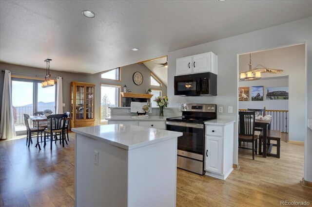32091 Black Widow Dr, Conifer, CO 80433 - kitchen featuring black microwave, stainless steel electric range oven, light countertops, white cabinets, and a center island