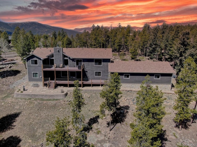 32091 Black Widow Dr, Conifer, CO 80433 - back of property with a chimney and a deck with mountain view