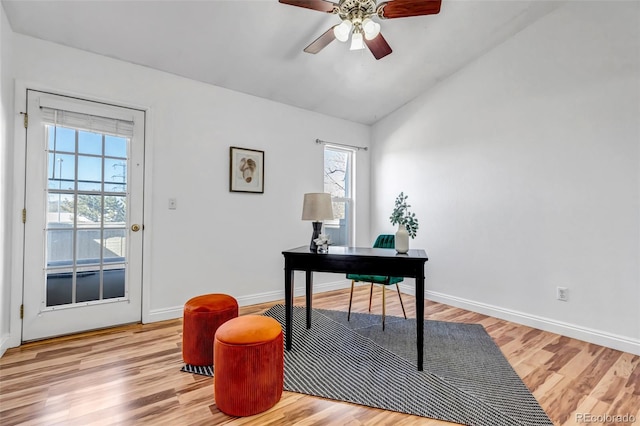 office area featuring lofted ceiling, light wood finished floors, baseboards, and a ceiling fan