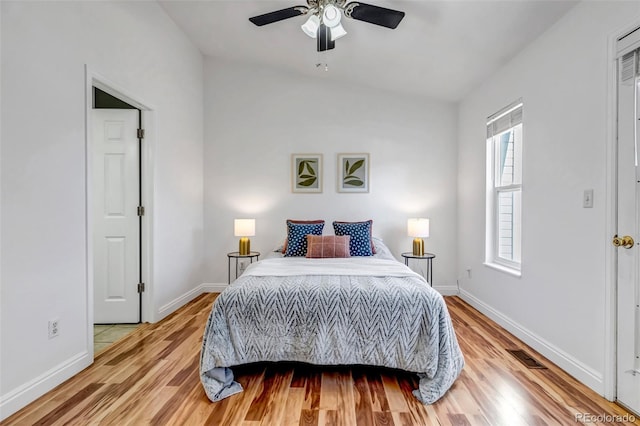 bedroom with light wood-type flooring, visible vents, ceiling fan, and baseboards