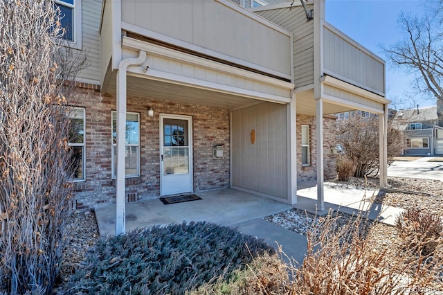 property entrance featuring brick siding